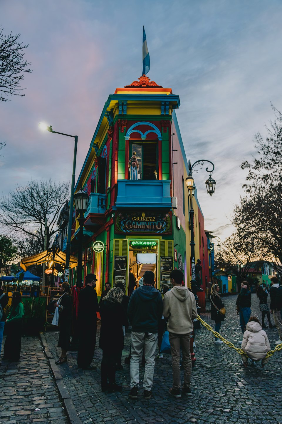 Una persona tiene un trofeo da una finestra colorata di un edificio.