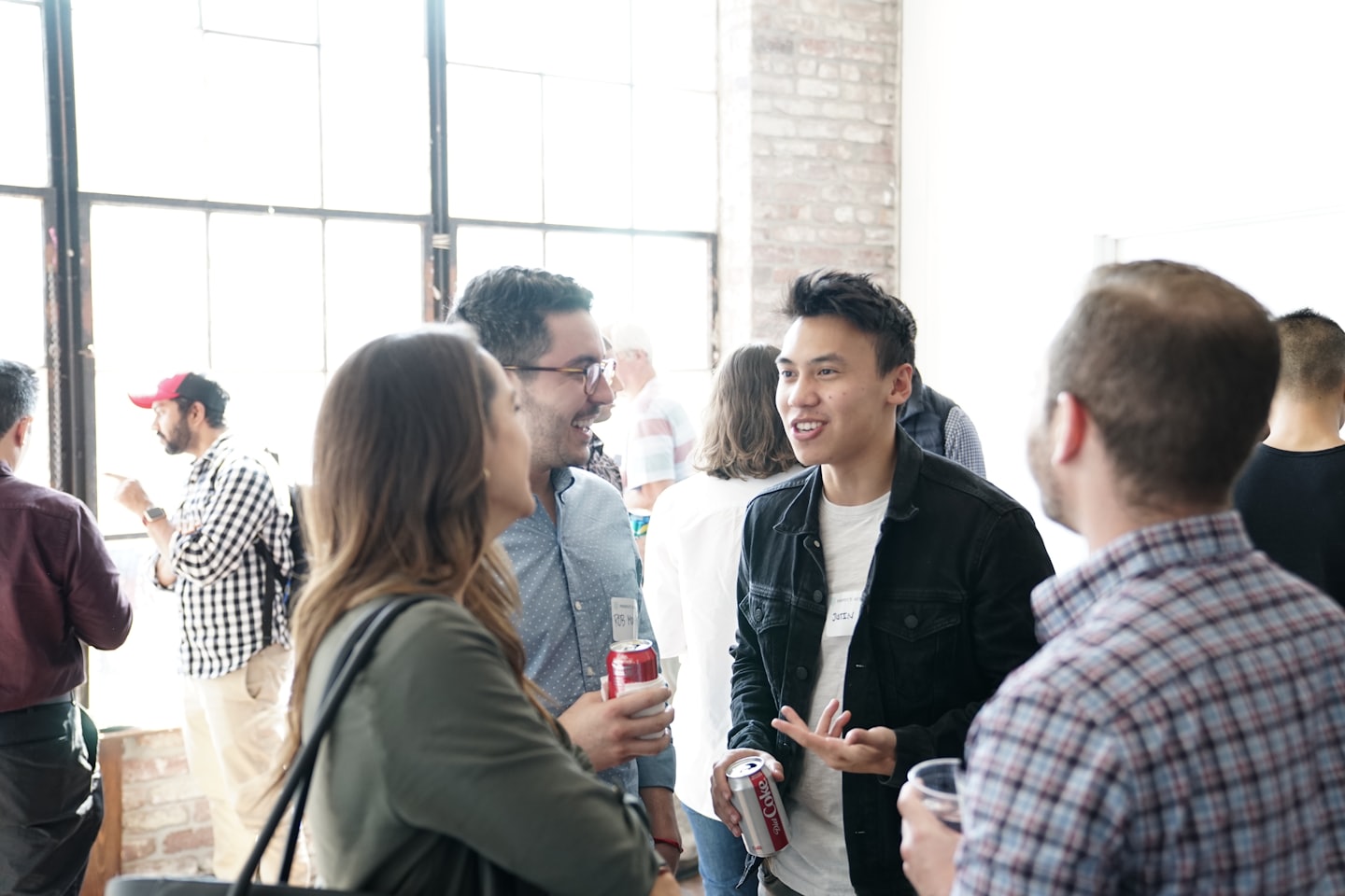 Professionisti diversi che fanno rete e conversano a un evento al chiuso.